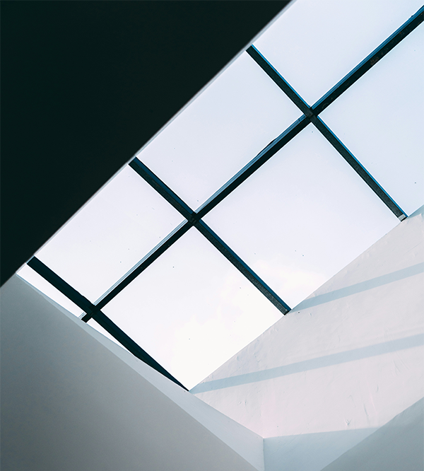 The sky shown through a glass ceiling at the top of a commercial building to represent workplace air quality importance.