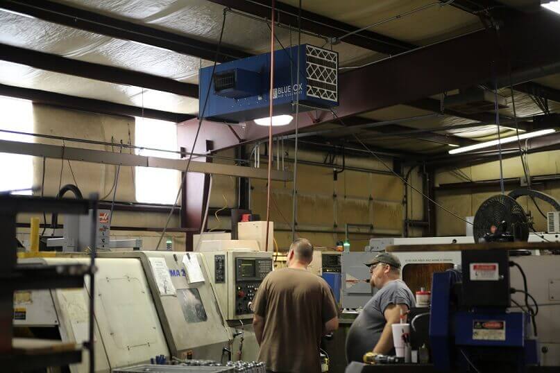 Blue Ox Air Cleaners unit hanging at machining facility to remove black process dust.